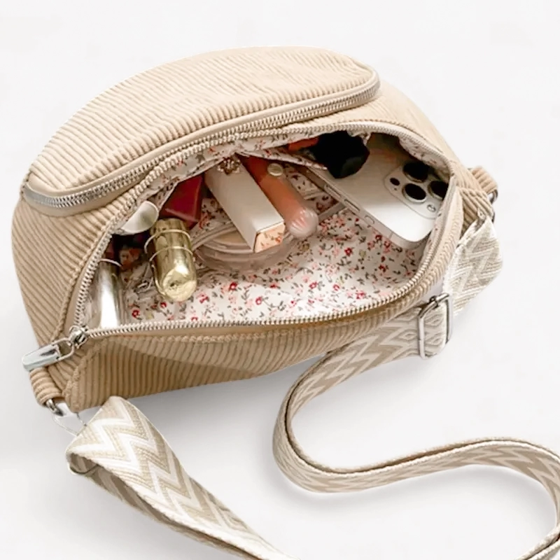 Beige corduroy bum bag open with make-up and a phone in the main compartment